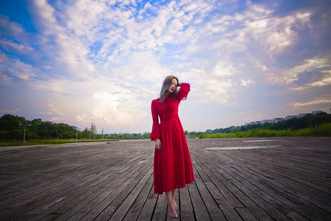 Bir kadının kırmızı elbise giydiği rüya anını betimleyen, dramatik renk vurgusuna sahip görsel