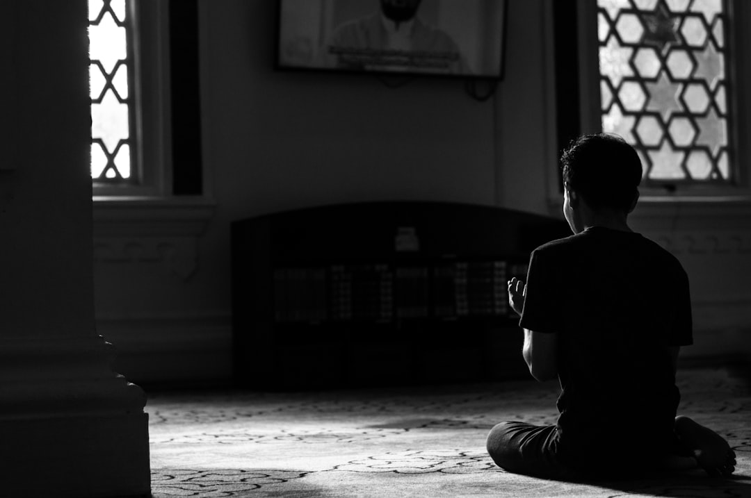 Bir kişi iç mekanda dua ederken sakinleşen anı yakalanmış görüntü